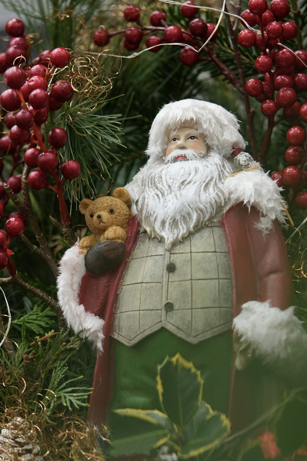 a statue of santa claus holding a teddy bear