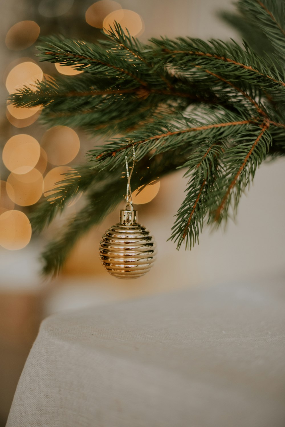 a christmas ornament hanging from a pine tree