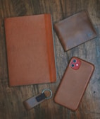 a leather case, keychain, and wallet on a table
