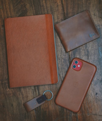 a leather case, keychain, and wallet on a table