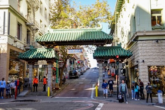 a group of people walking down a street next to tall buildings