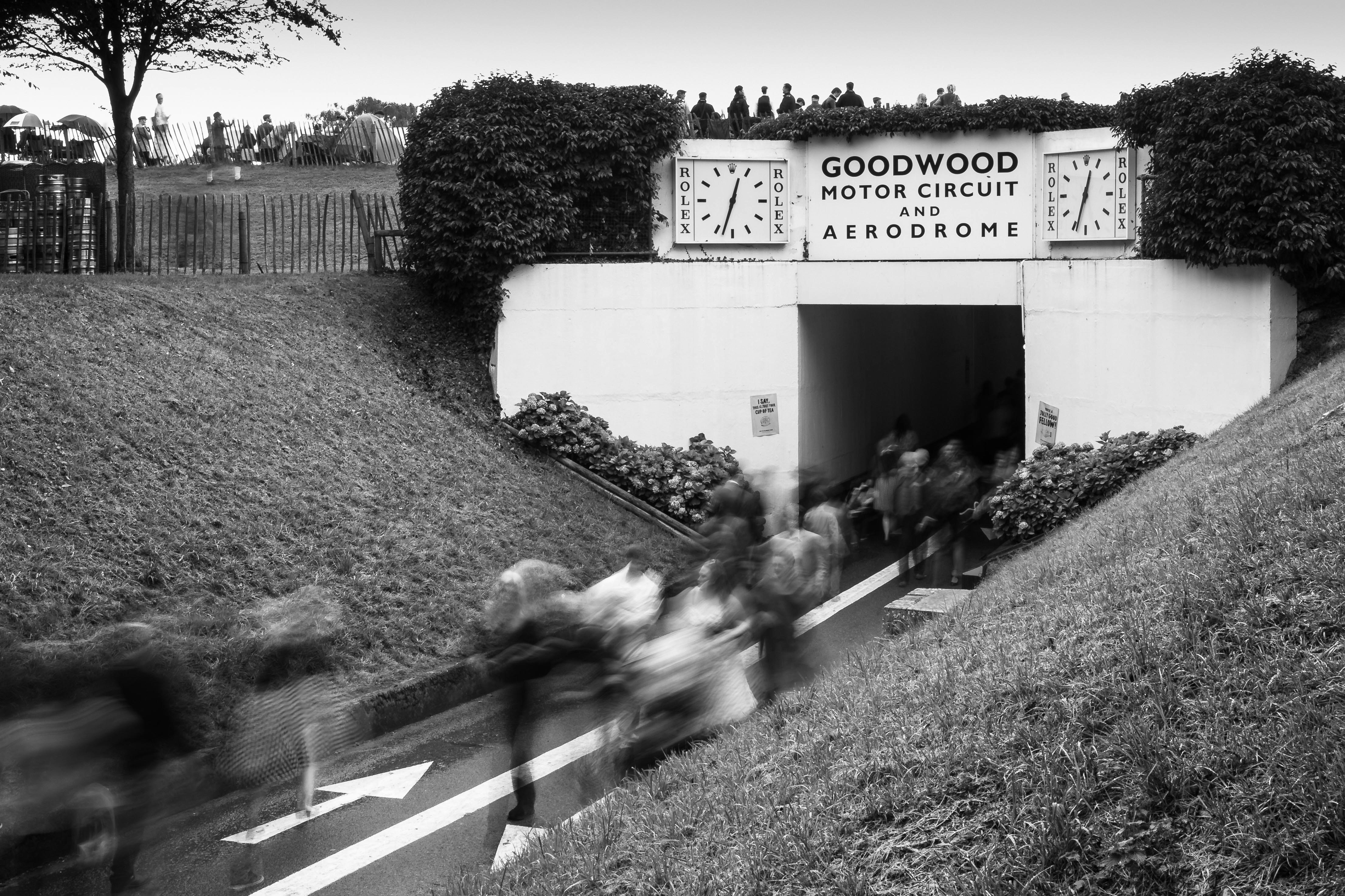 a black and white photo of people walking up a hill