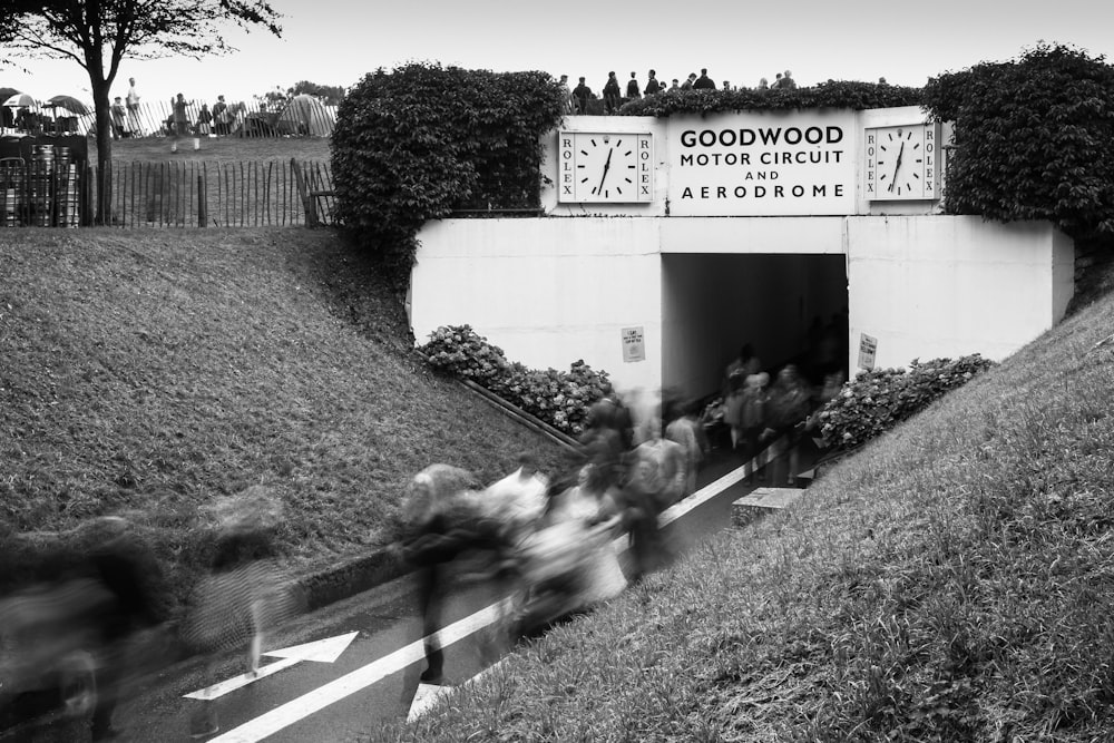 a black and white photo of people walking up a hill