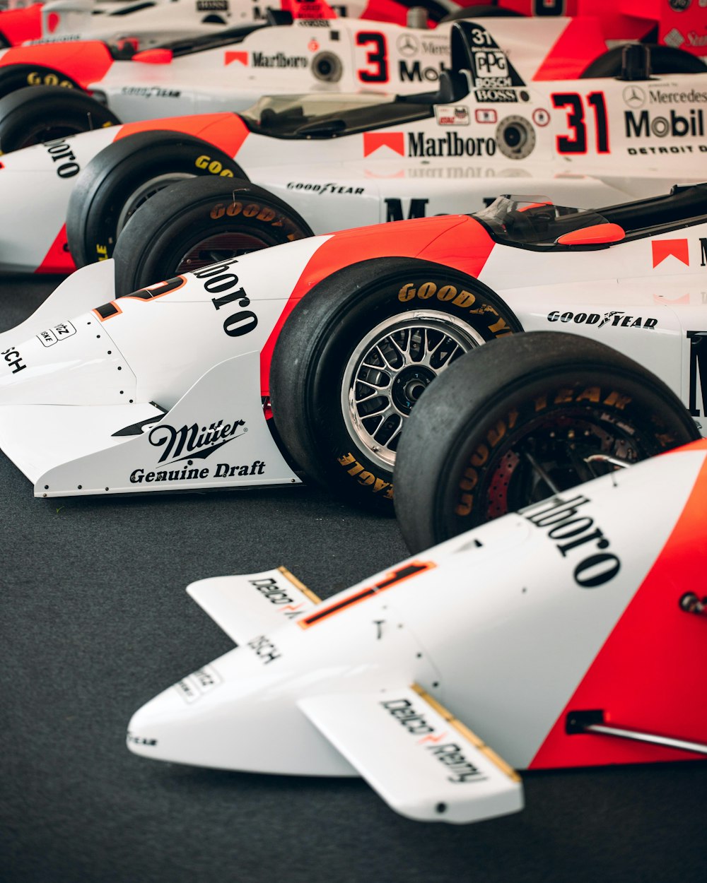 a row of racing cars sitting on top of a black floor