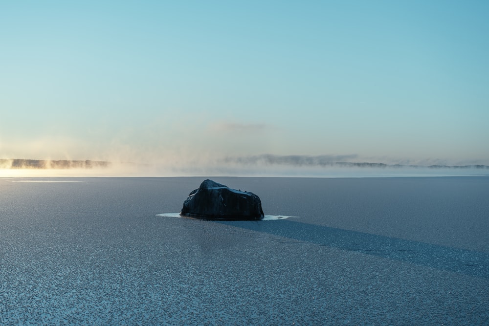 una grande roccia seduta sulla cima di un lago ghiacciato