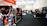 A trade show or exhibition hall with multiple booths lined along the aisles. People are interacting and exploring different displays. Some individuals are wearing masks. The hall is well-lit with banners and promotional materials displayed prominently.