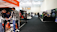 A trade show or exhibition hall with multiple booths lined along the aisles. People are interacting and exploring different displays. Some individuals are wearing masks. The hall is well-lit with banners and promotional materials displayed prominently.