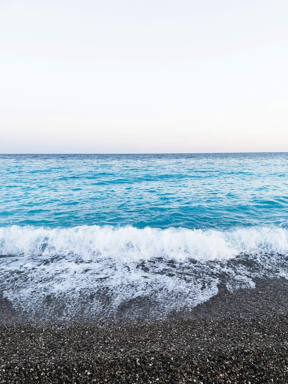 an ocean view with waves coming in and out of the water