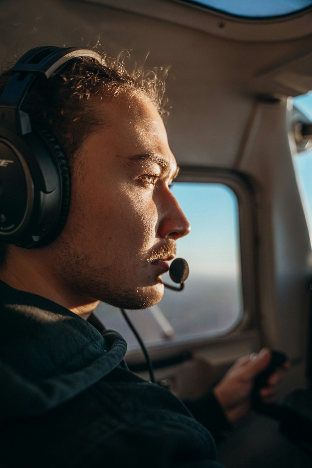 a man wearing headphones while sitting in a plane