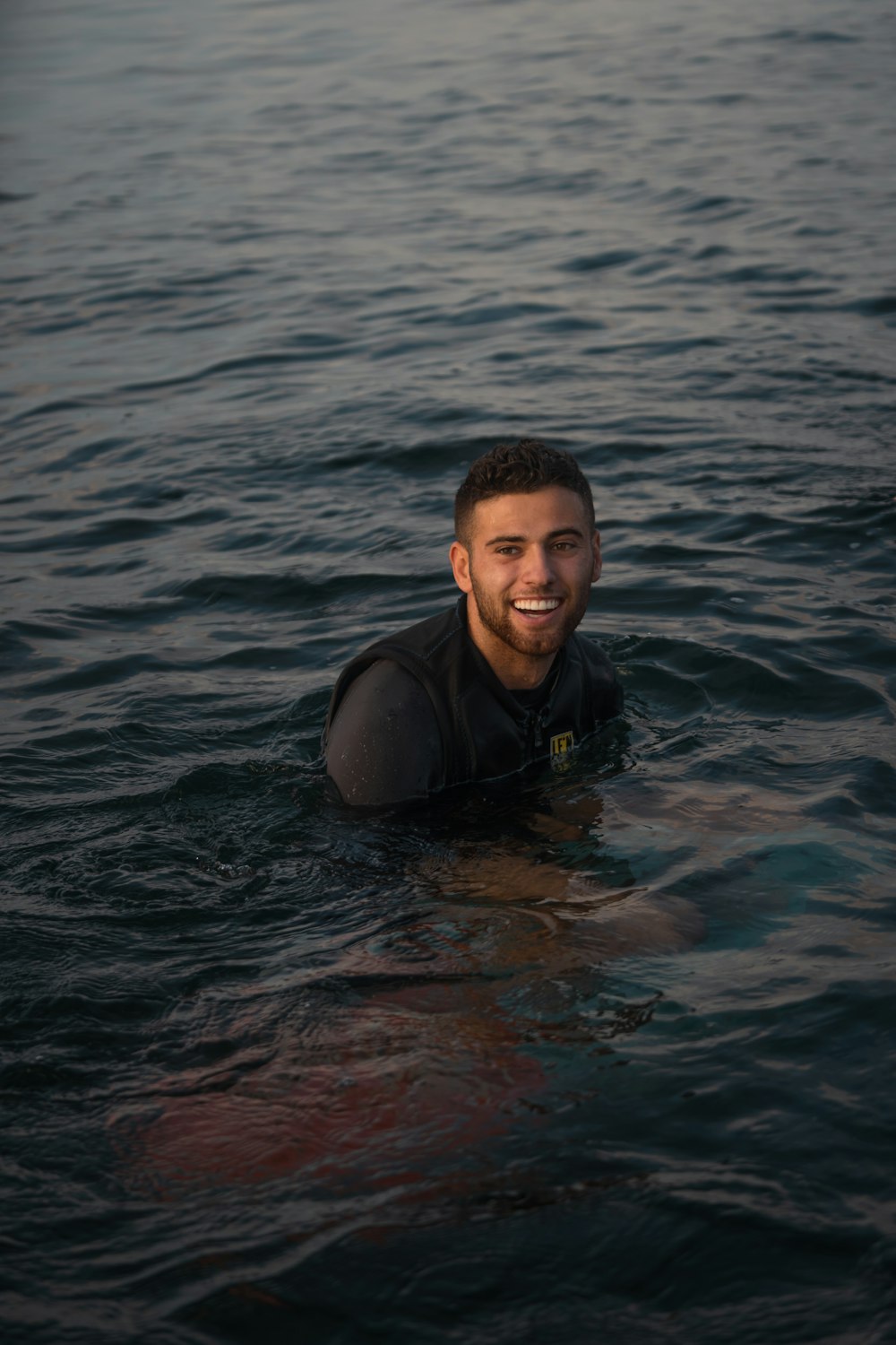 a man in a wet suit swimming in the ocean