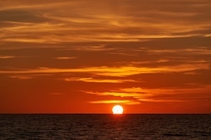 A vibrant sunset over the ocean, creating a picturesque backdrop for evening relaxation.