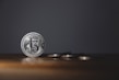 Shiny silver coins arranged in a fan shape on a wooden table