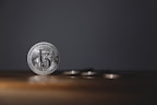 Shiny silver coins arranged in a fan shape on a wooden table