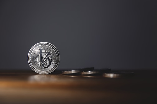 A neatly arranged display of vintage silver coins on a dark wooden surface.