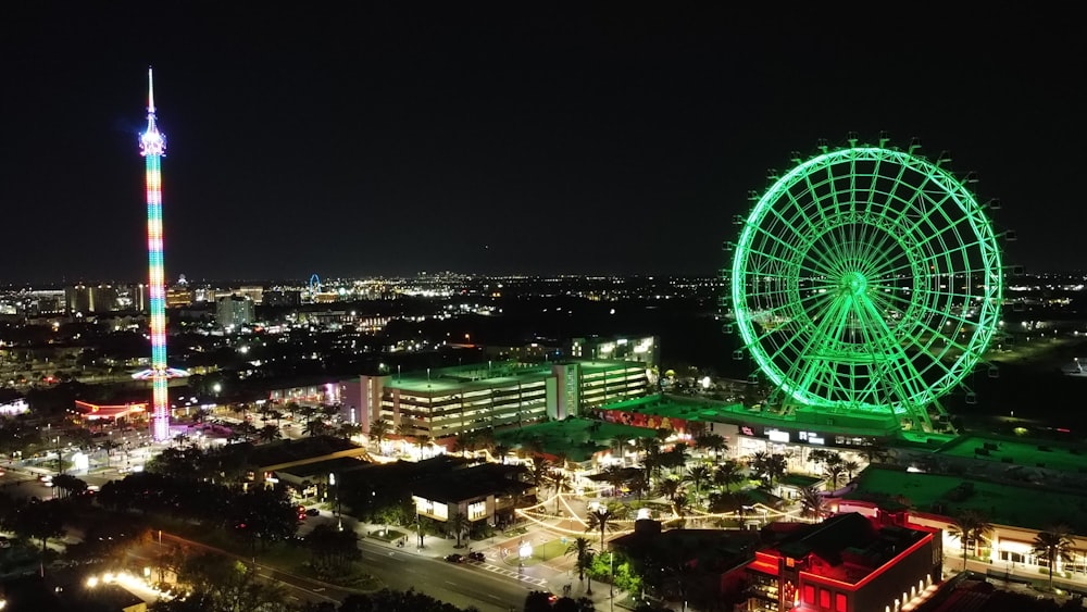 a ferris wheel lit up at night in a city