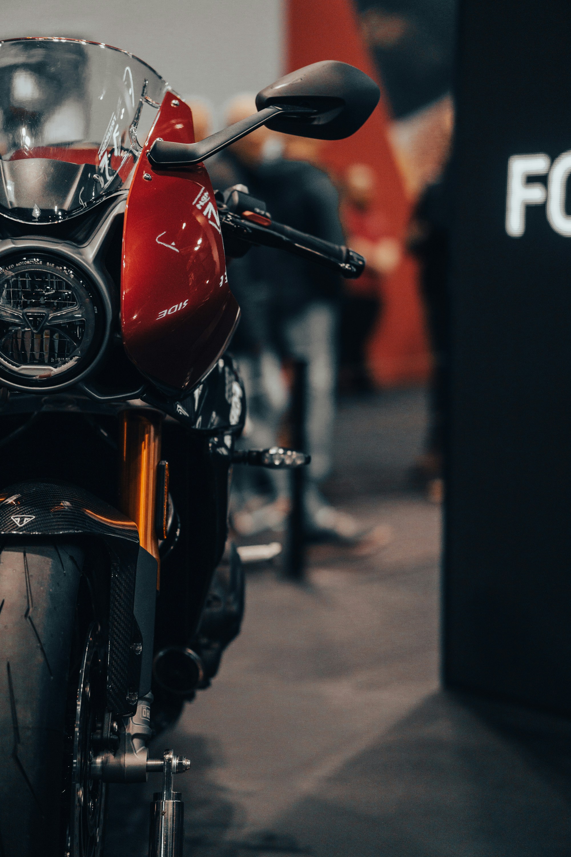 Close up of a red motorcycle on display at an exhibition