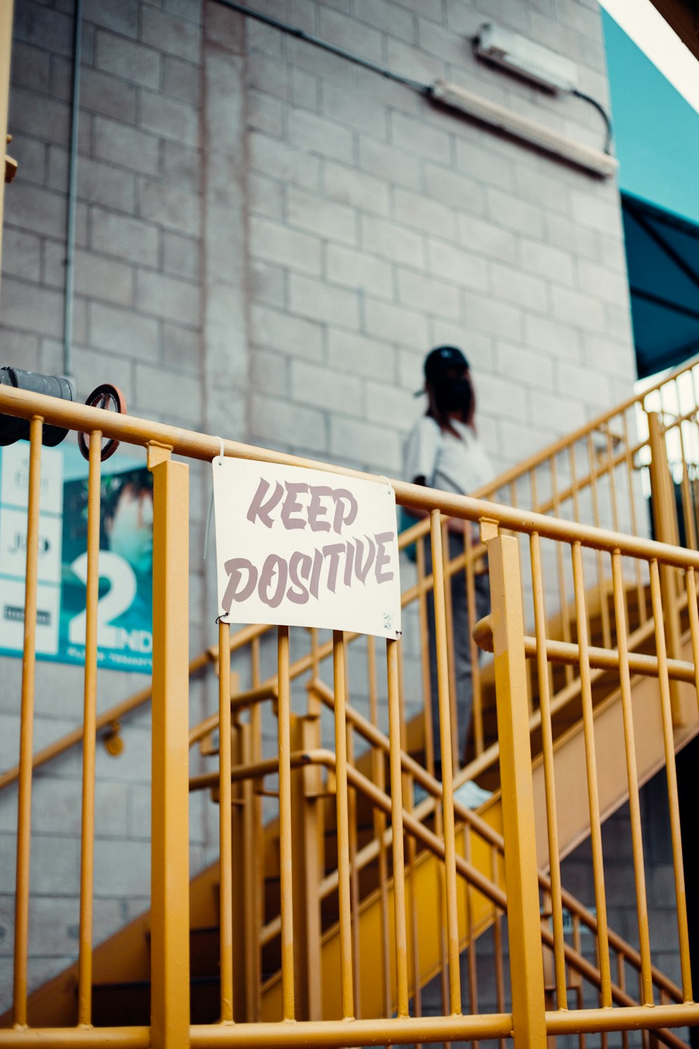 a sign that says keep positive on a railing