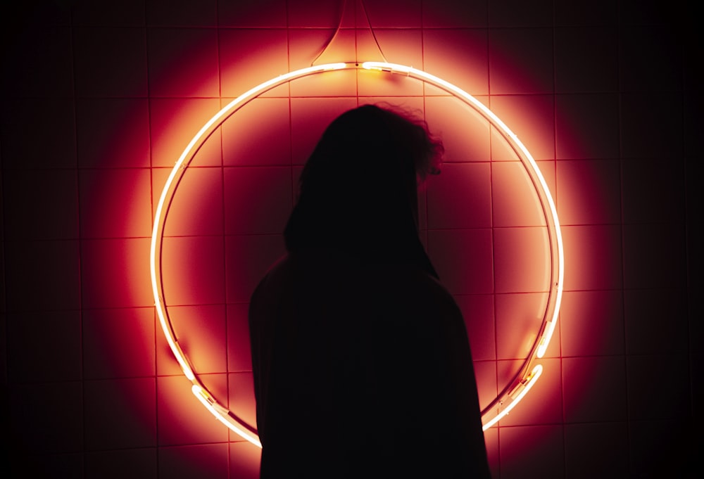 a person standing in front of a neon circle