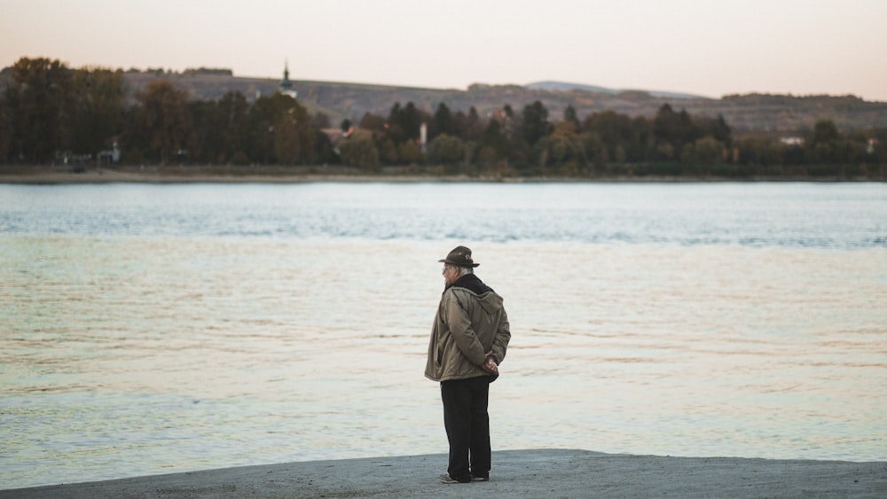 a man standing on the edge of a body of water