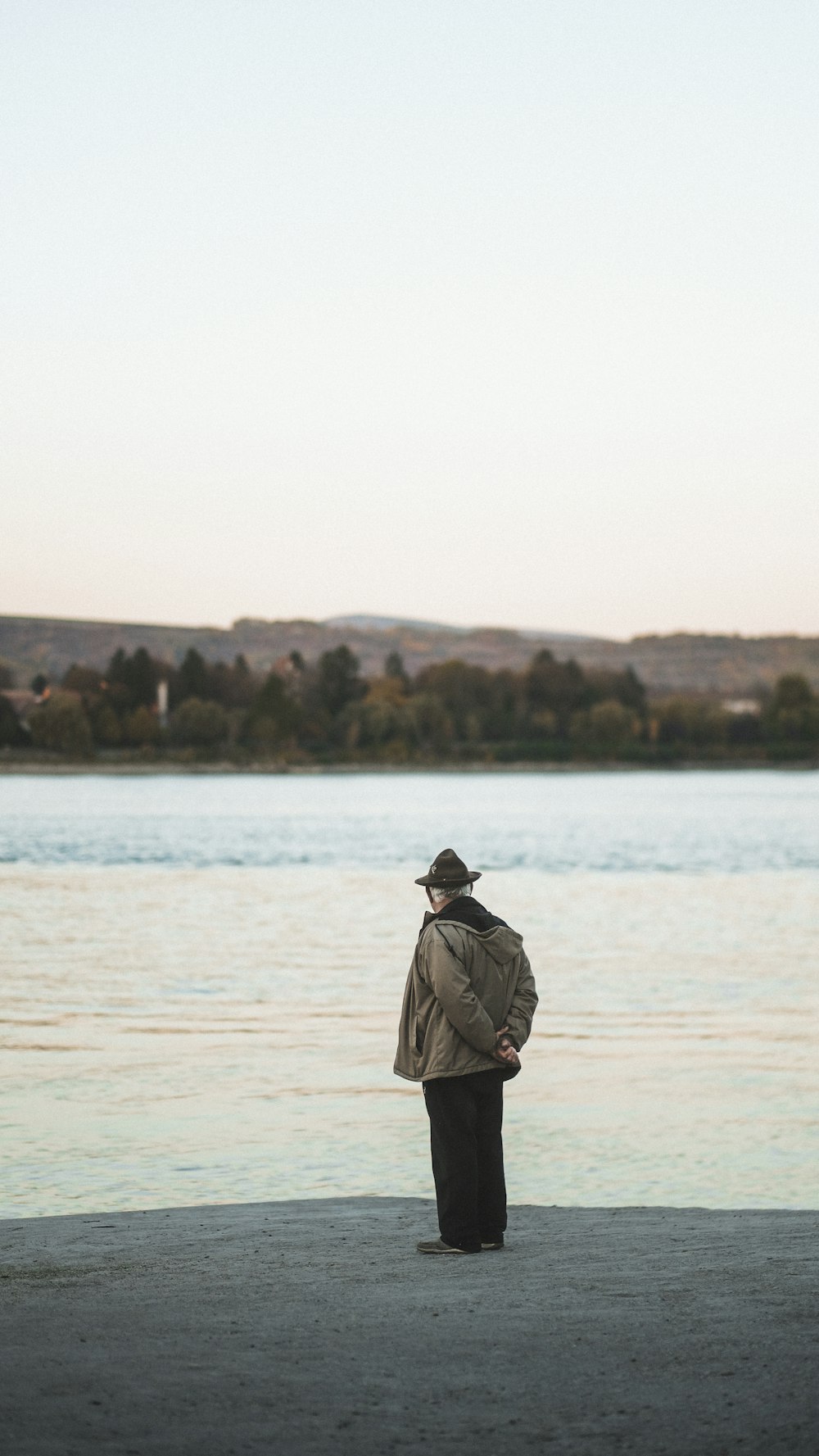 a man standing on a beach next to a body of water