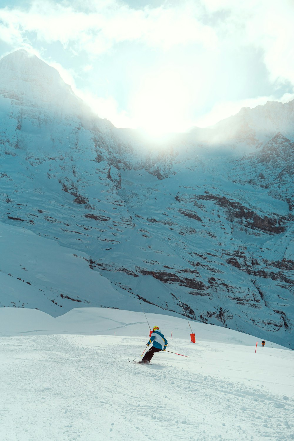 a person skiing down a snowy mountain with mountains in the background