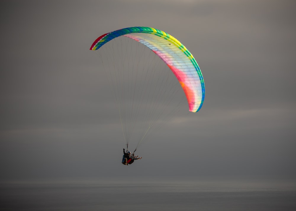 a person is parasailing in the ocean on a cloudy day