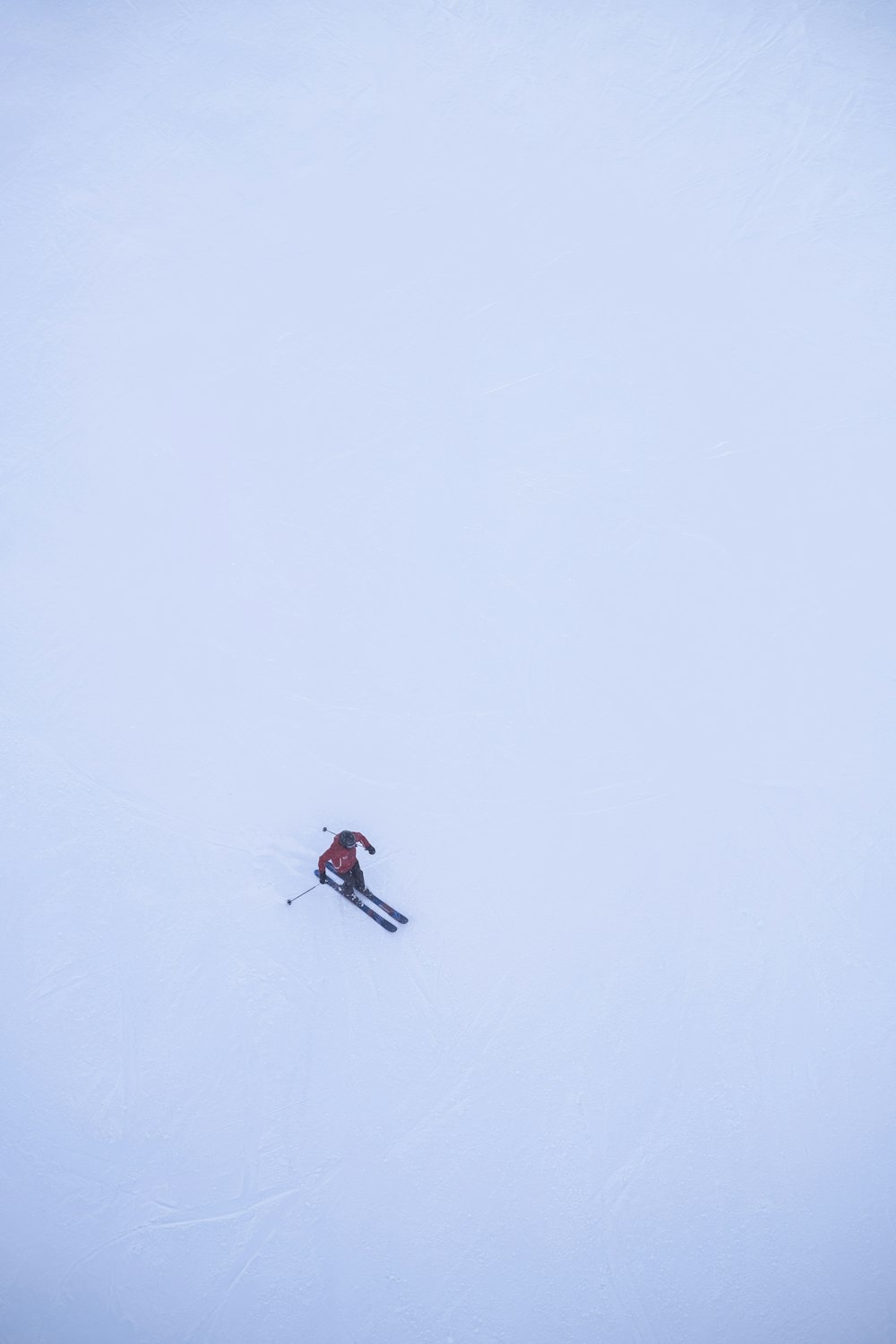 a person riding skis down a snow covered slope