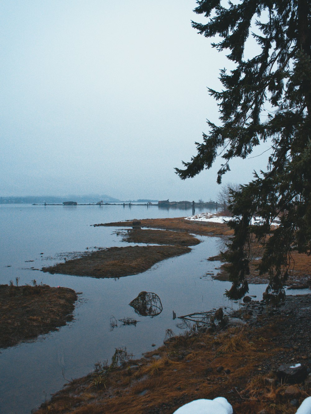 a body of water surrounded by snow covered ground