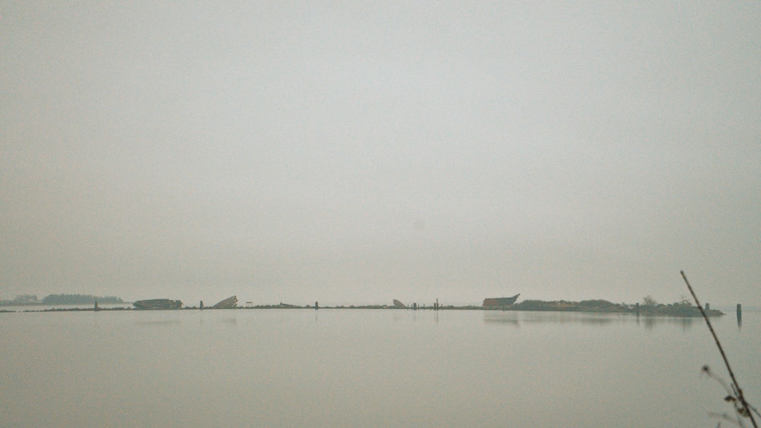 a large body of water with a boat in the distance,