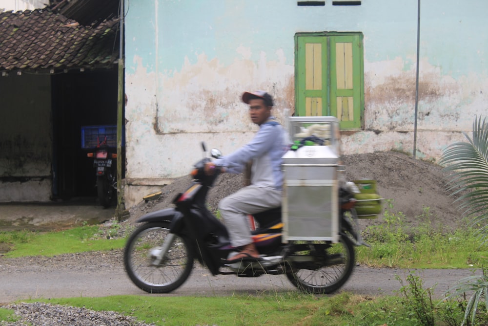 a man riding a motorcycle with a cart on the back of it