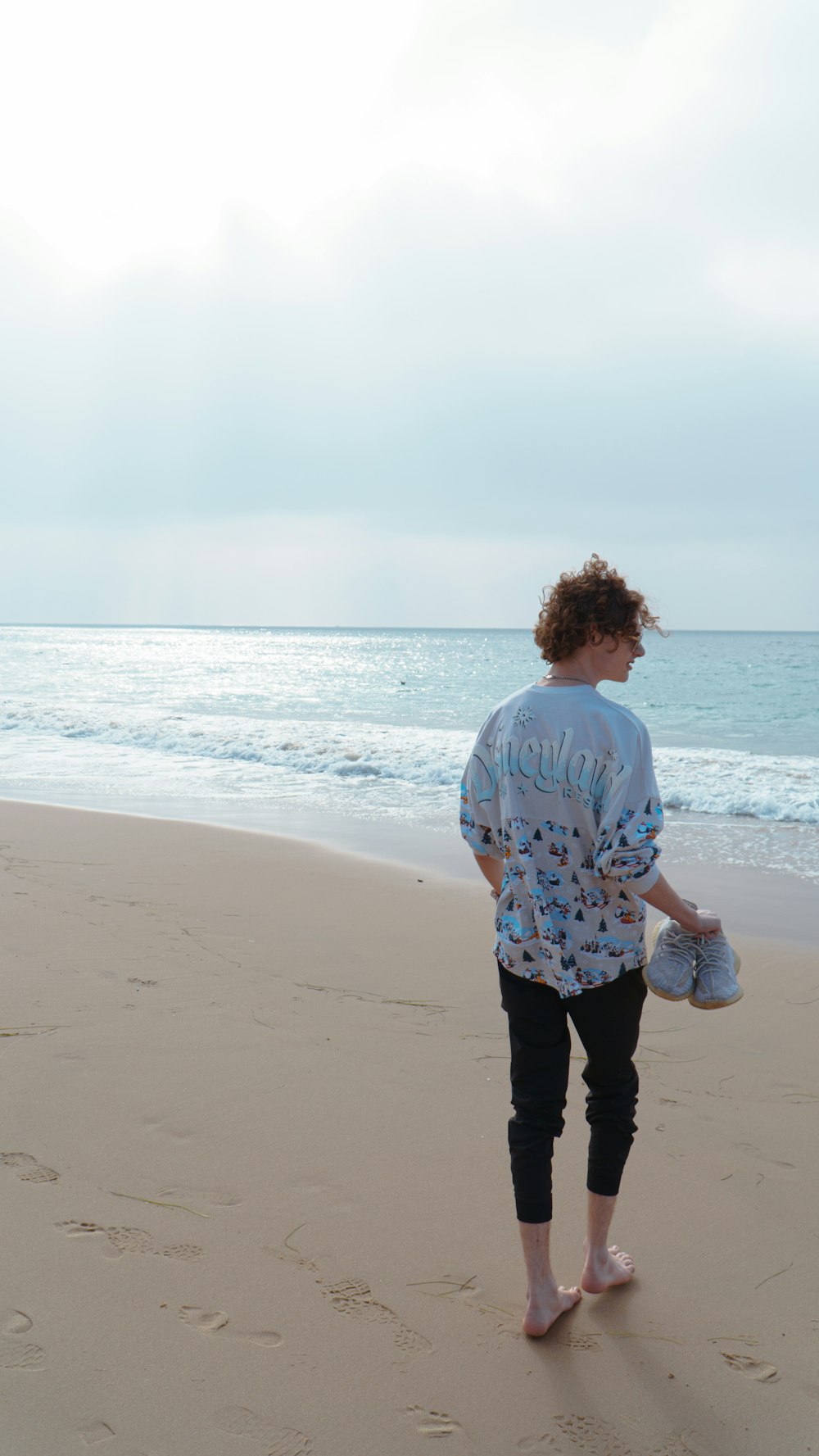 海の近くのビーチを歩いている人