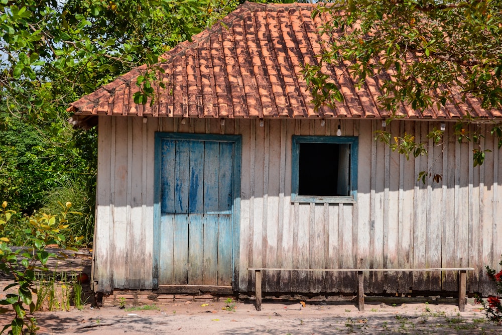 a small wooden building with a blue door and window