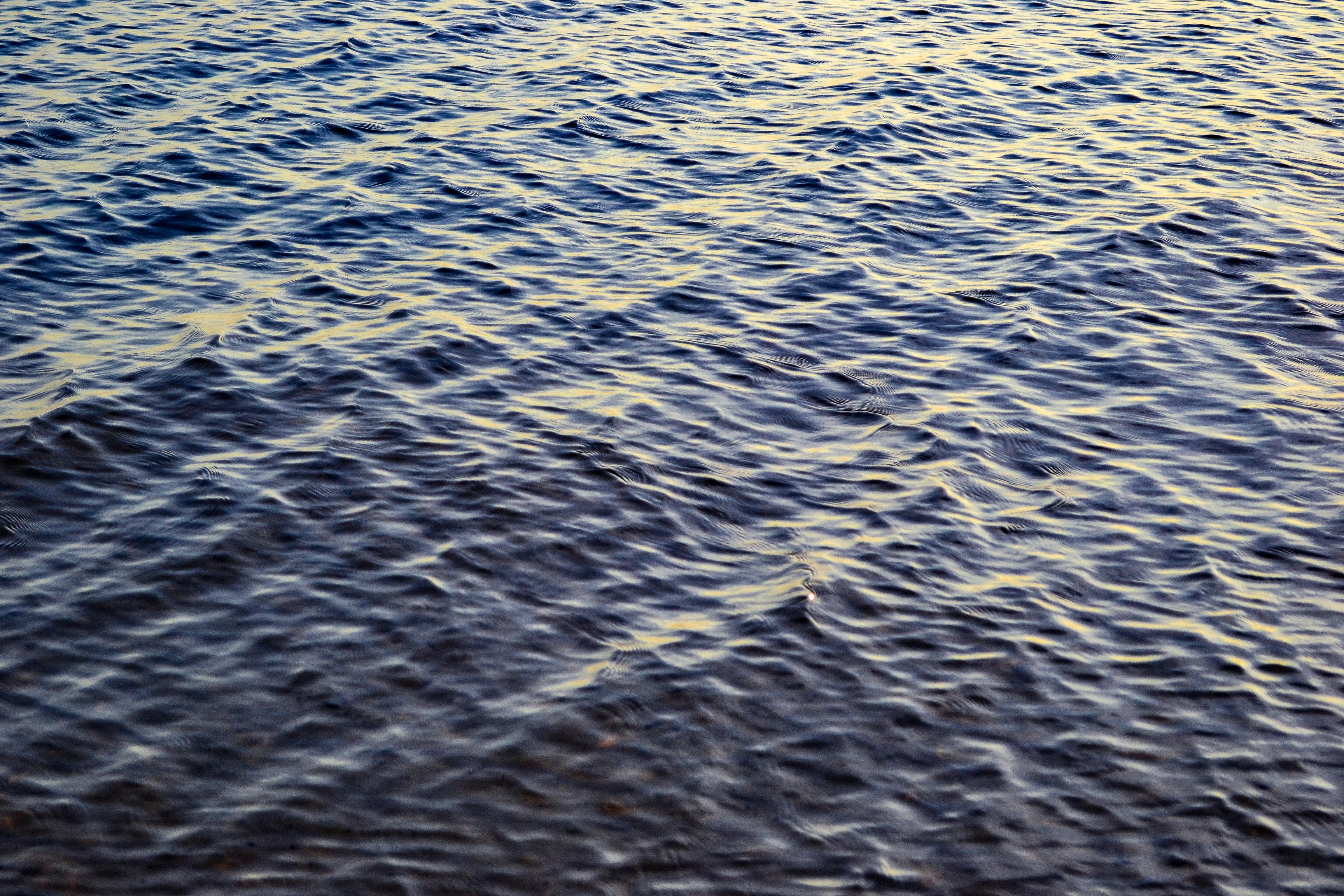 a large body of water with a boat in the distance