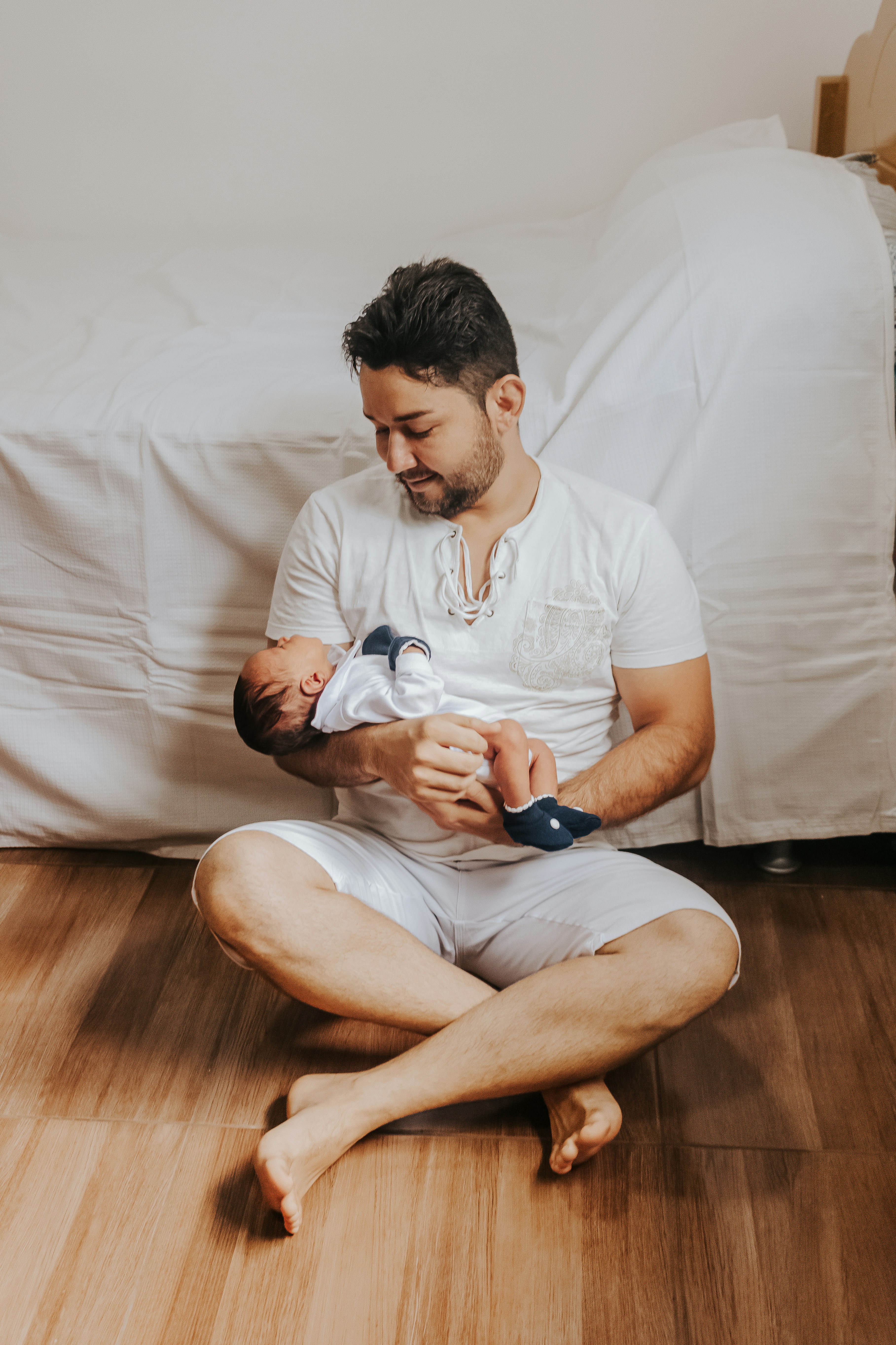 a man sitting on the floor holding a baby