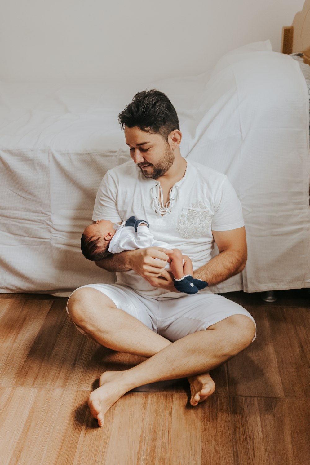 a man sitting on the floor holding a baby