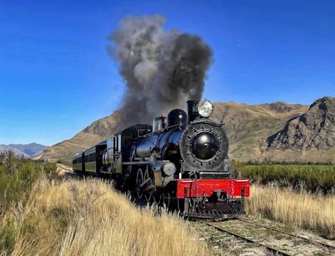 a steam engine train traveling through a rural countryside