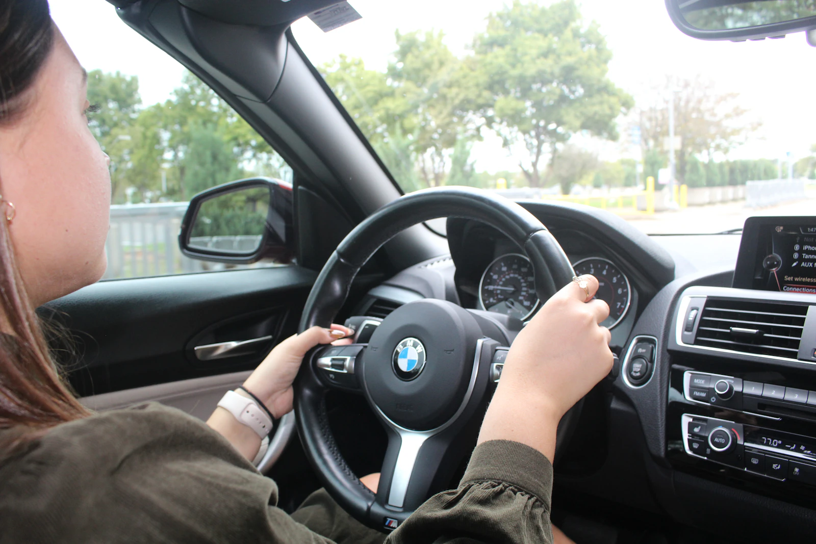 Smiling student confidently driving with sunlight streaming through the window