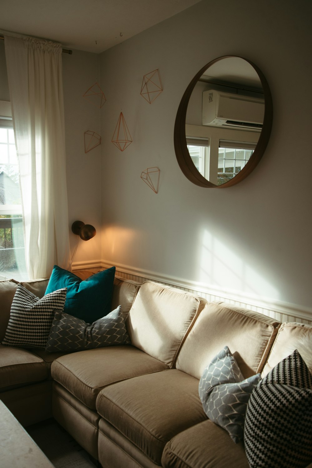 a living room with a couch and a mirror on the wall