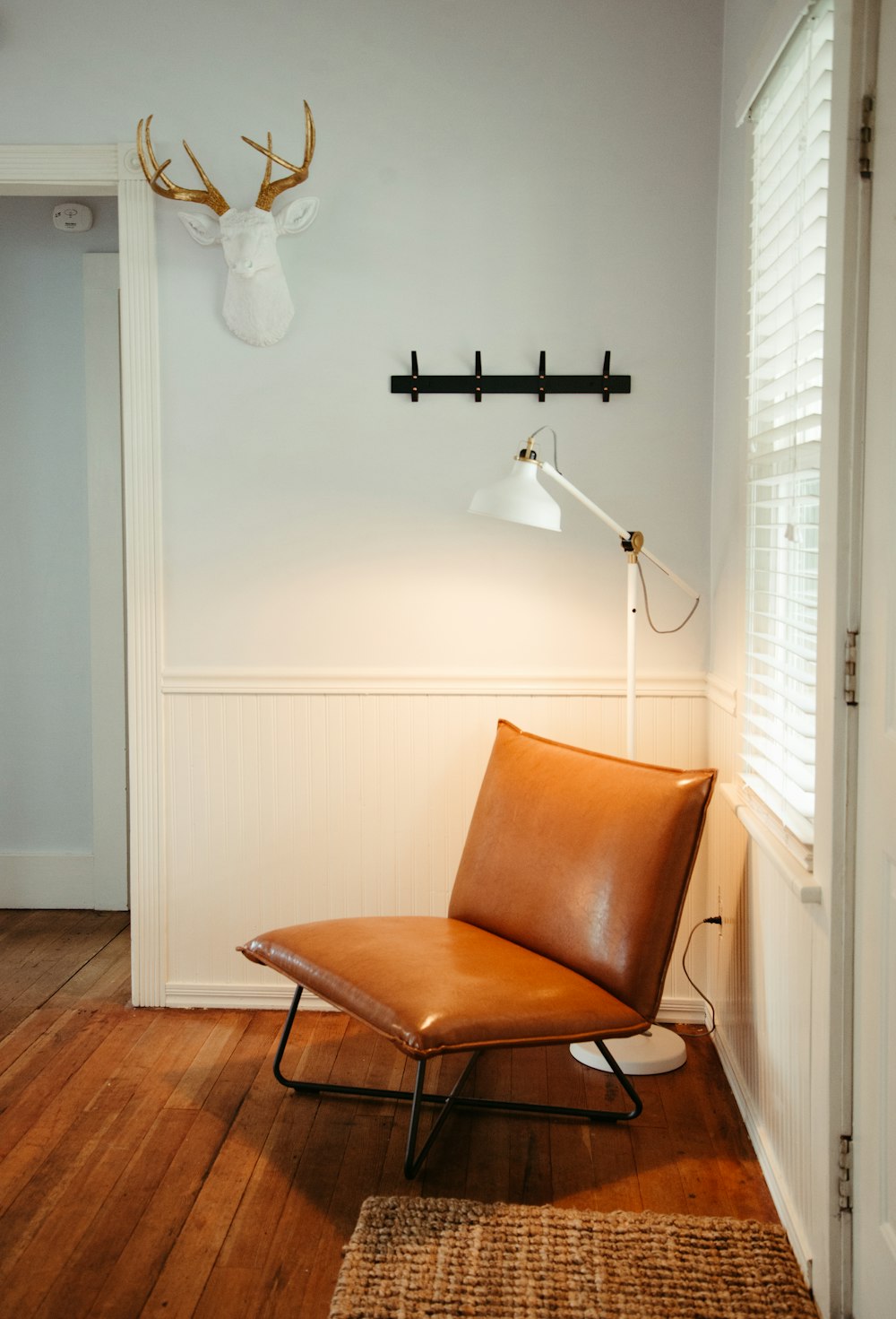 a brown chair sitting in a room next to a lamp