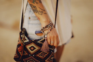 a woman with a tattoo on her arm holding a purse