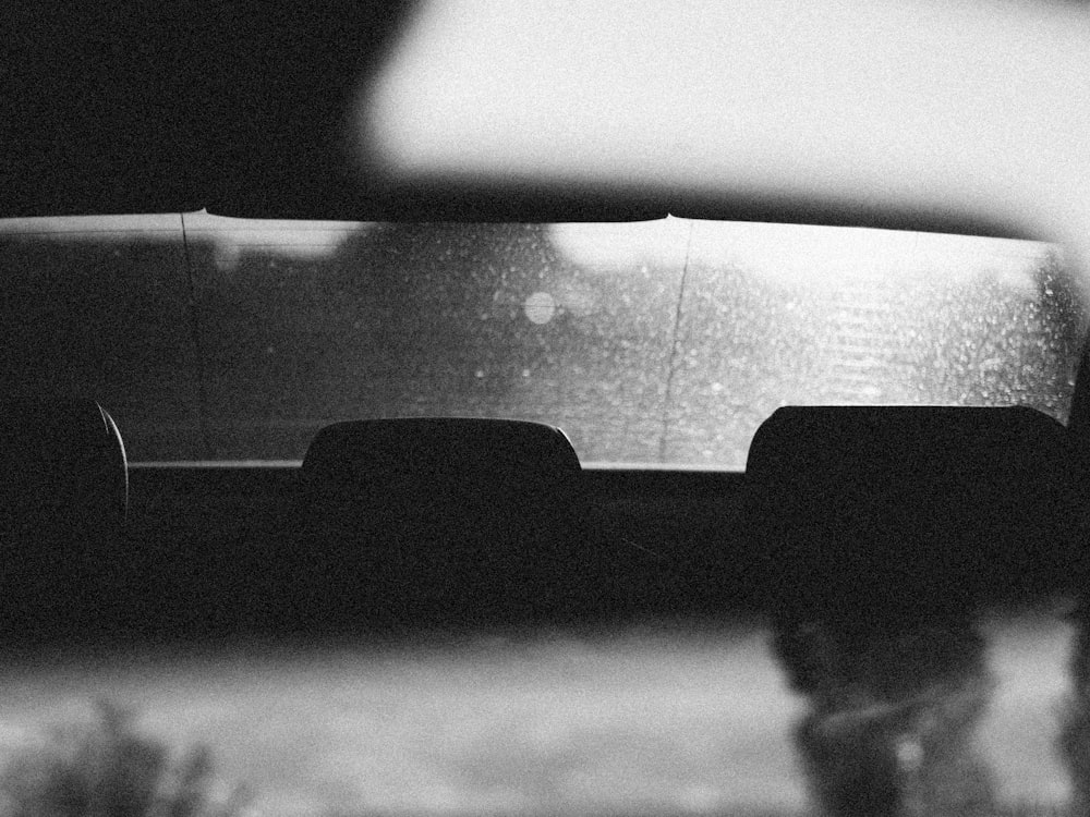 a black and white photo of a car in the rain