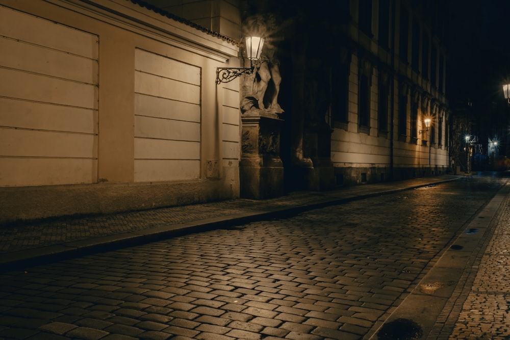a cobblestone street at night with lights on