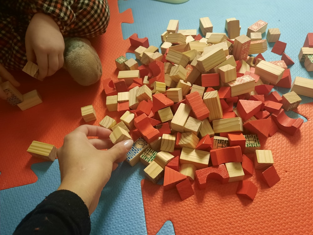 a child is playing with wooden blocks on the floor