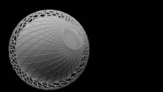 A geometrically intricate sphere sits prominently against a stark black background. The sphere is constructed with a complex lattice structure, offering a sense of depth and curvature. The metallic or reflective surface of the sphere adds to the modern and abstract feel of the image.