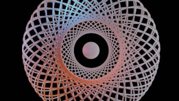 A symmetrical geometric pattern with intricate interwoven lines forms a circular design against a black background. At the center, there is a perfectly round, glowing sphere.