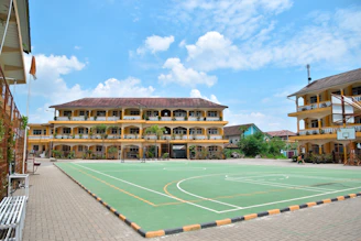 a large building with a basketball court in front of it