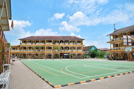 a large building with a basketball court in front of it