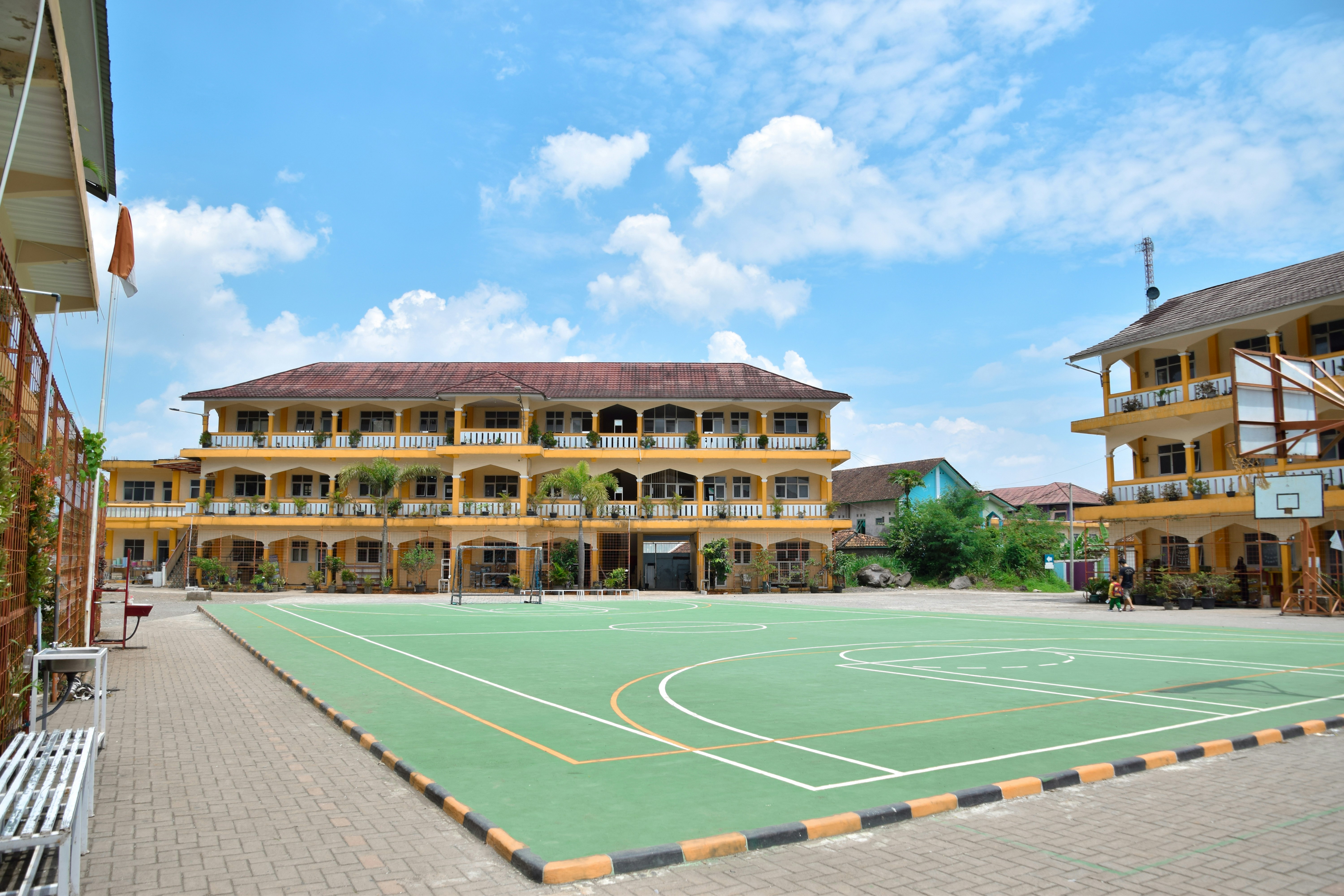 a large building with a basketball court in front of it