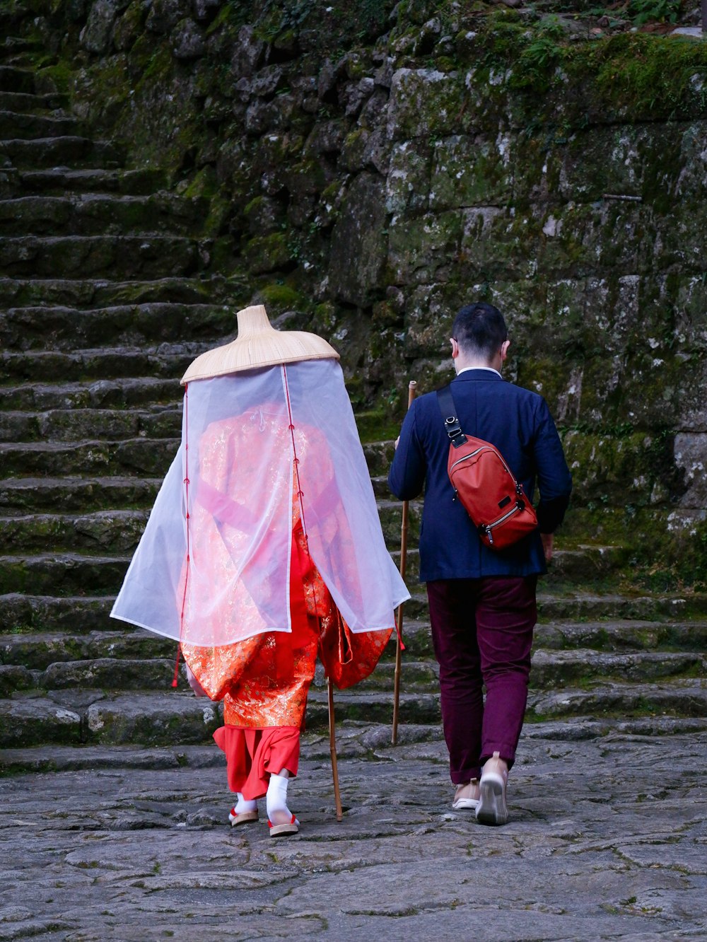 two people walking up some steps with a pink umbrella