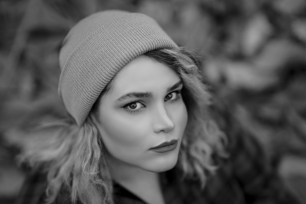 a black and white photo of a woman wearing a beanie